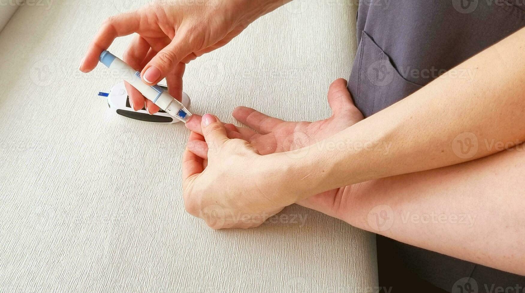 Close up shot of the glucometr instrument on the white surface. Nurse helping patient to check sugar level. Healthcare photo