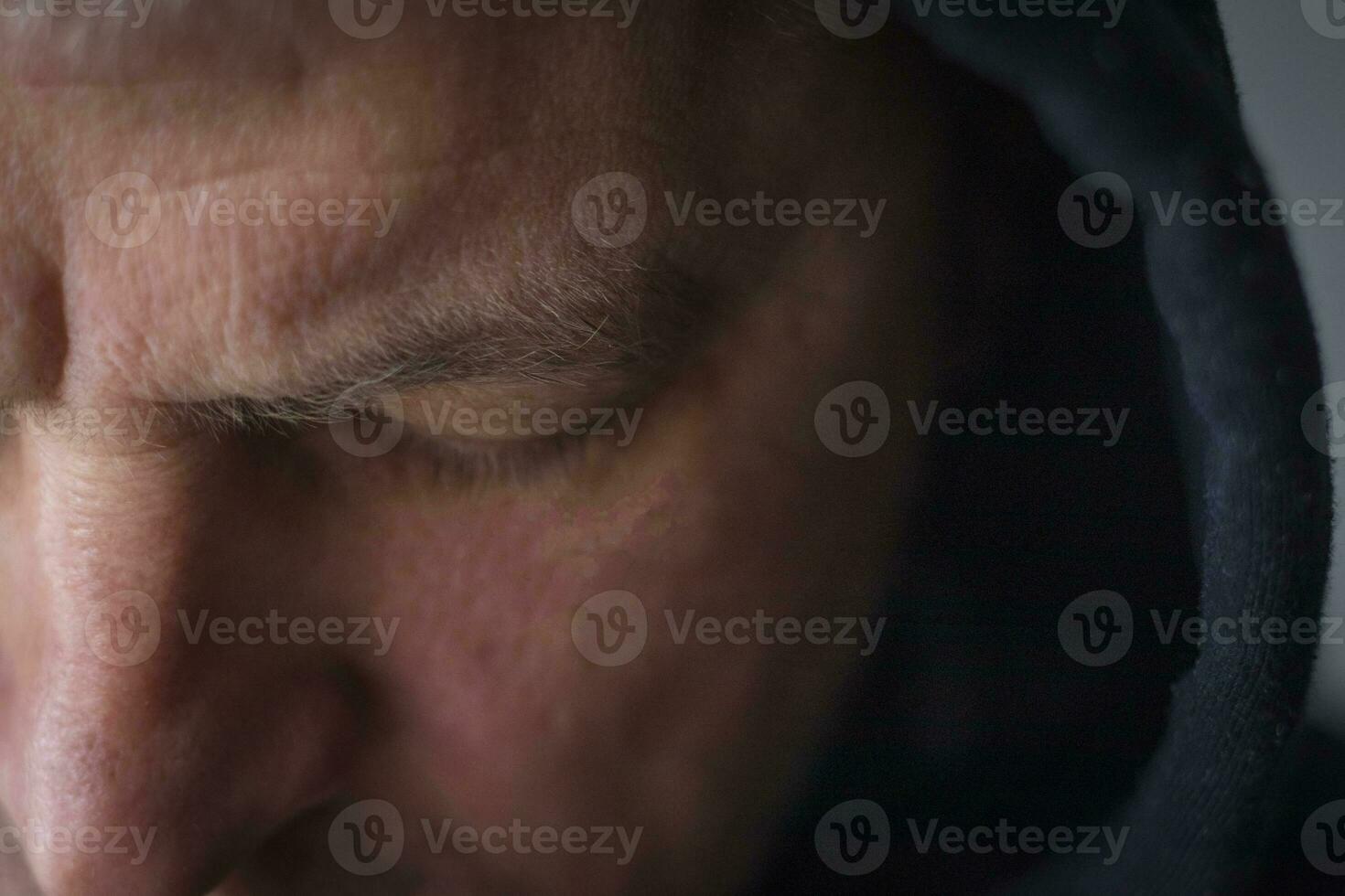 Man looked like hacker in a hood looking at the screen. People photo