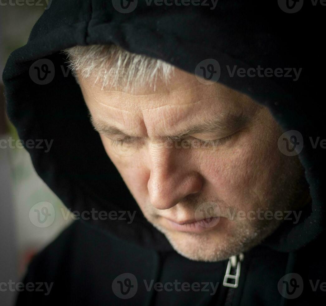 Man looked like hacker in a hood looking at the screen. People photo