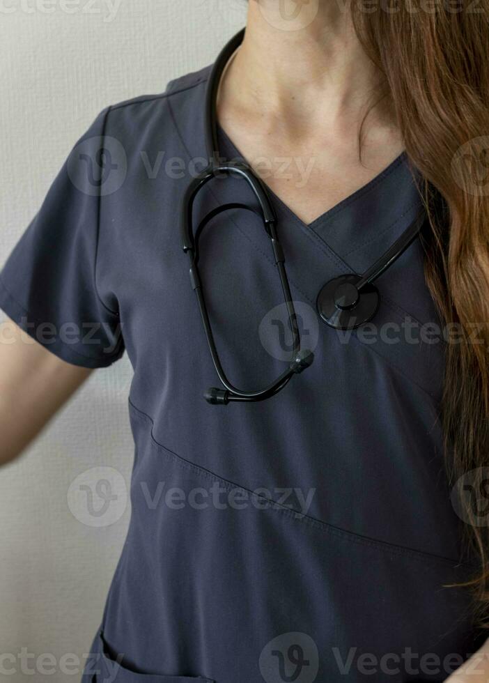 Shot of the female doctor in uniform against the white wall. Healthcare photo