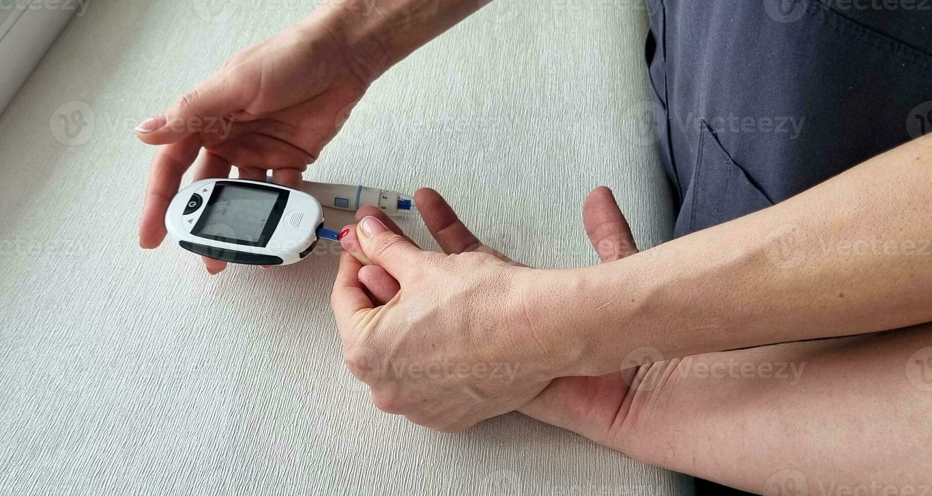 Close up shot of the glucometr instrument on the white surface. Nurse helping patient to check sugar level. Healthcare photo