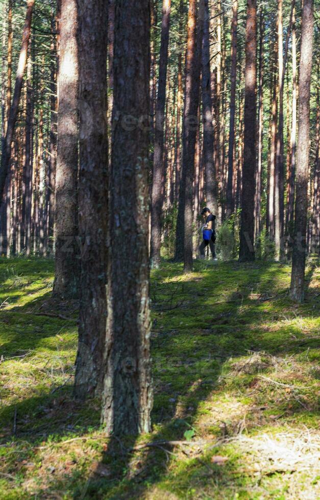 Shot of the young woman walking in the forest. Outdoors photo