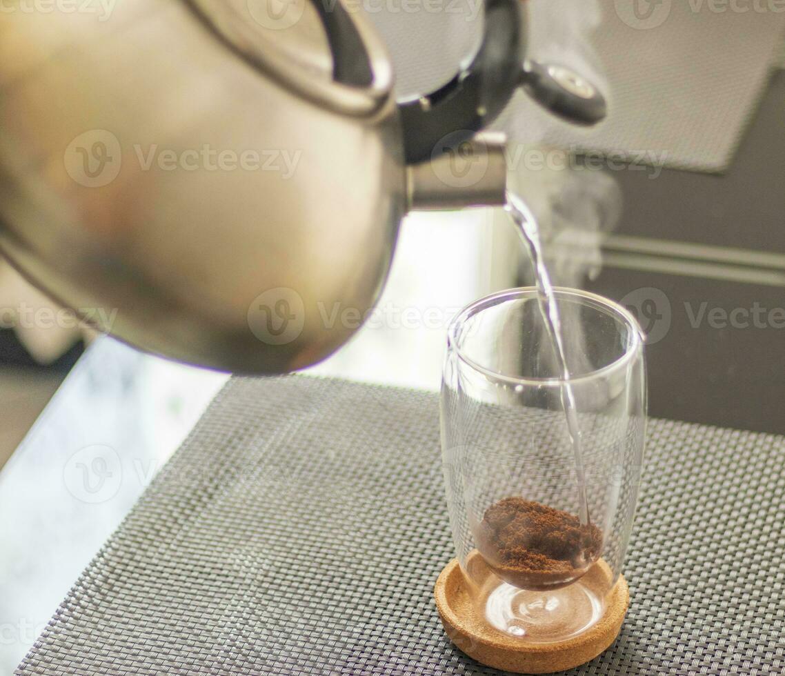 Shot of the hot water being poured into the transparent cup to brew the coffee. Beverage photo