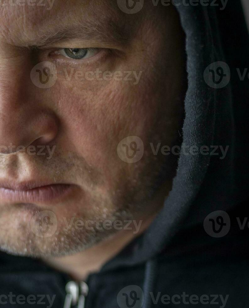 Man looked like hacker in a hood looking at the screen. People photo