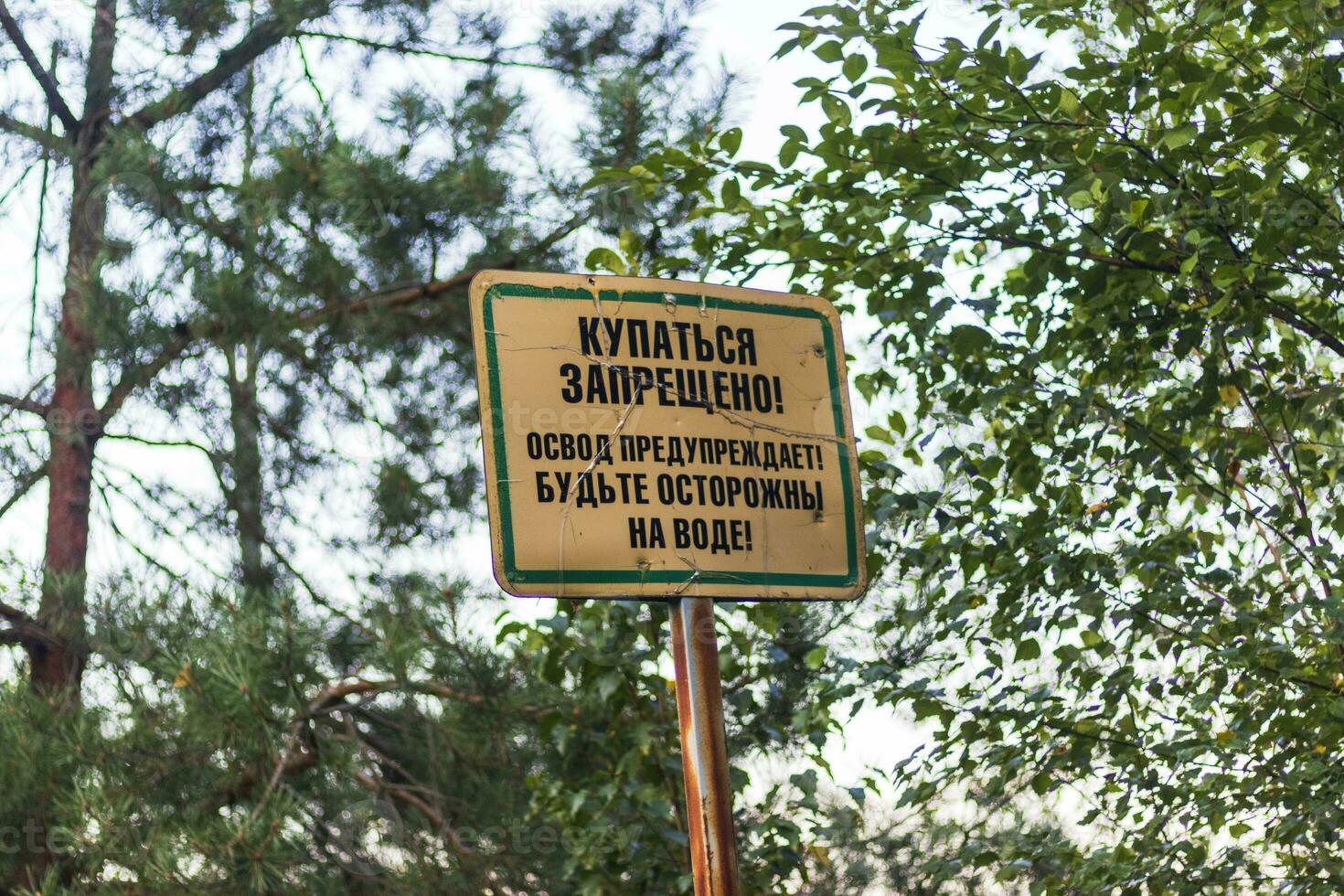 No swimming sign in Russian language next to the beach. Restriction photo