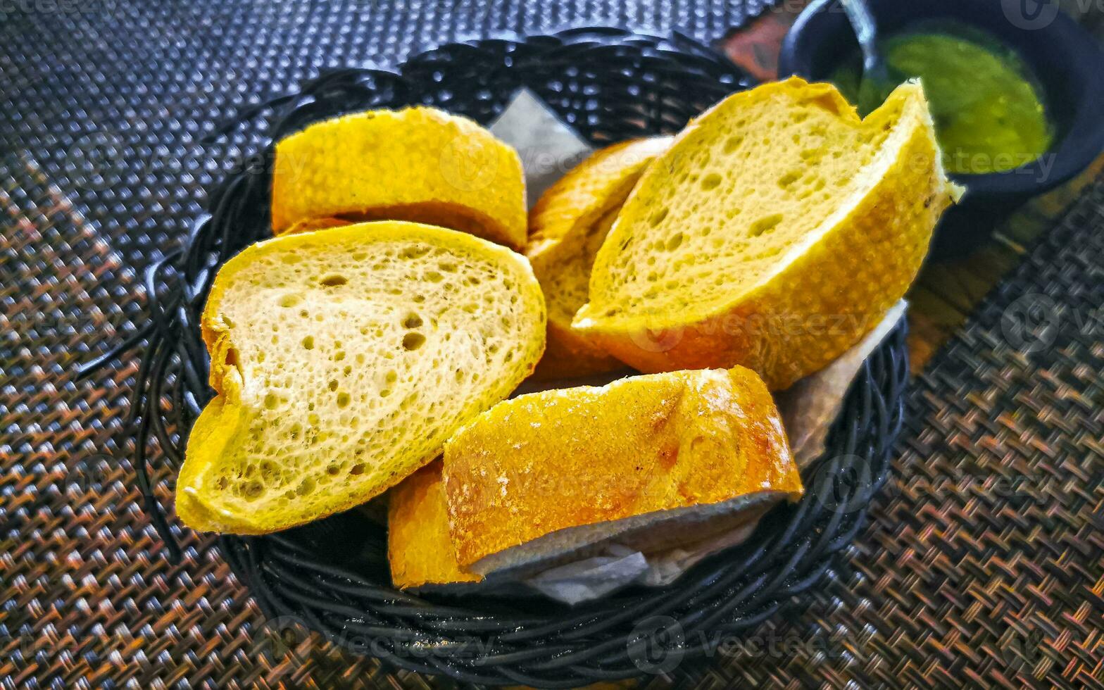 Bread in basket and green coriander sauce restaurant Mexico. photo