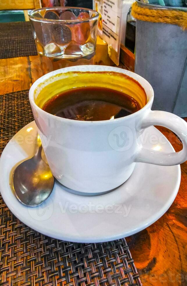 taza de americano negro café y vaso de agua cafetería. foto