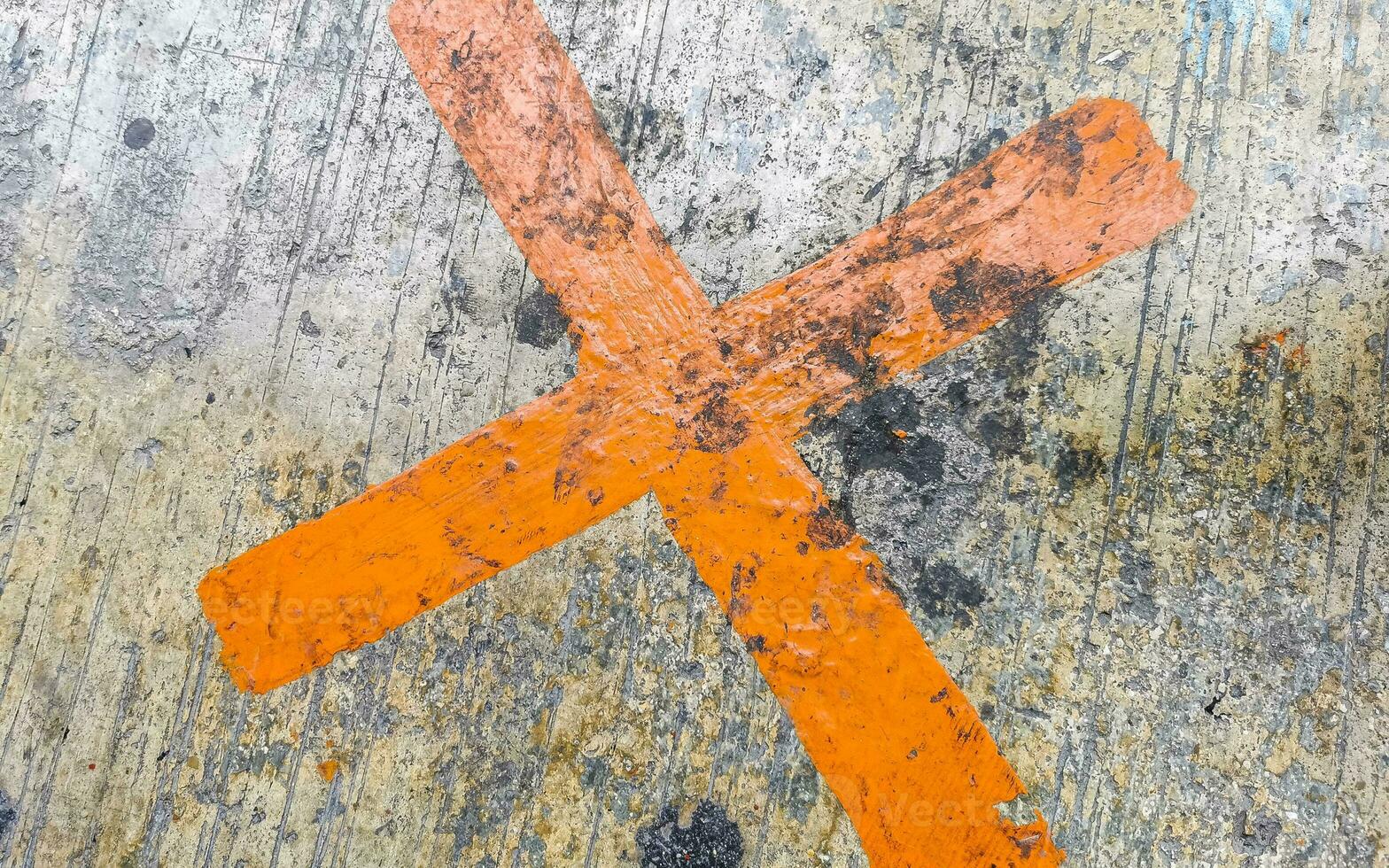 Orange painted cross on the sidewalk Playa del Carmen Mexico. photo