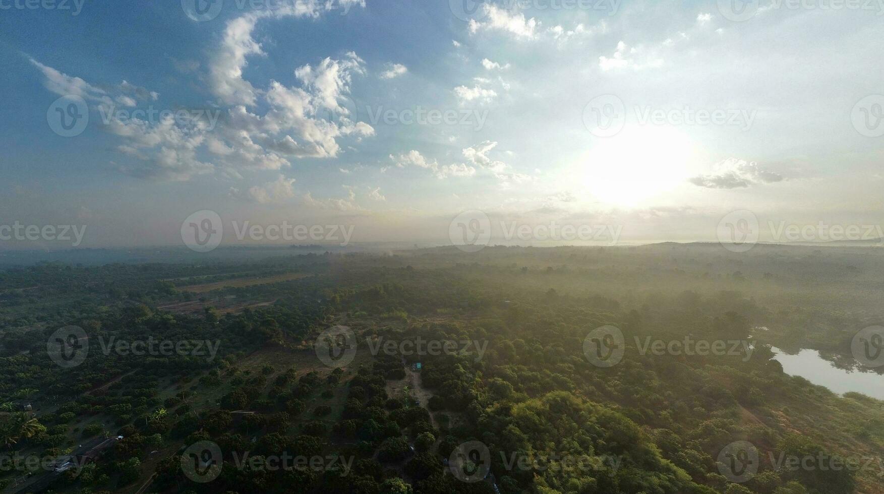 Aerial view of green field and blue sky with white clouds. photo