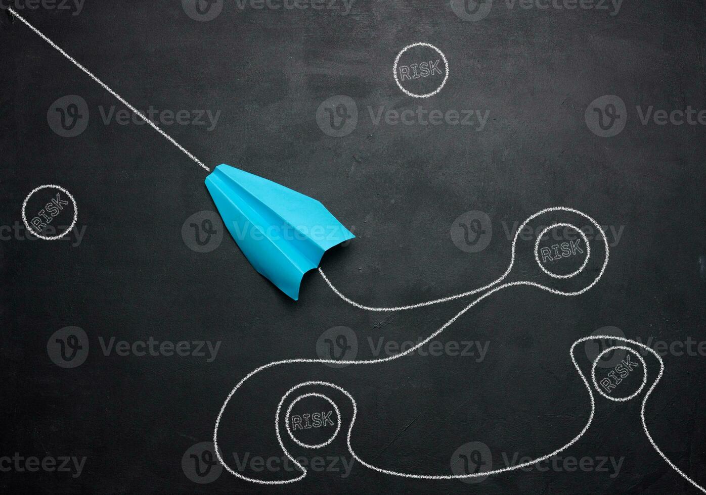 A blue paper boat and a trajectory navigating around risky situations photo