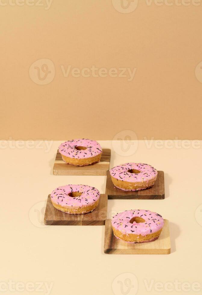 Donut covered with pink glaze and sprinkled with colorful sprinkles photo