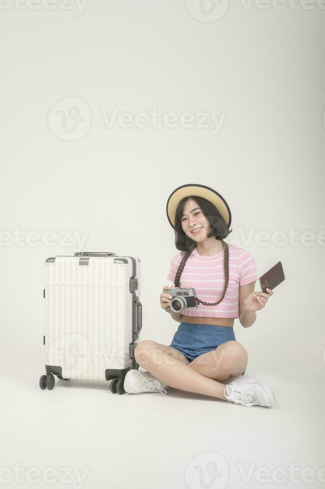 Young happy asian tourist woman over white background studio, travel and holidays concept. photo