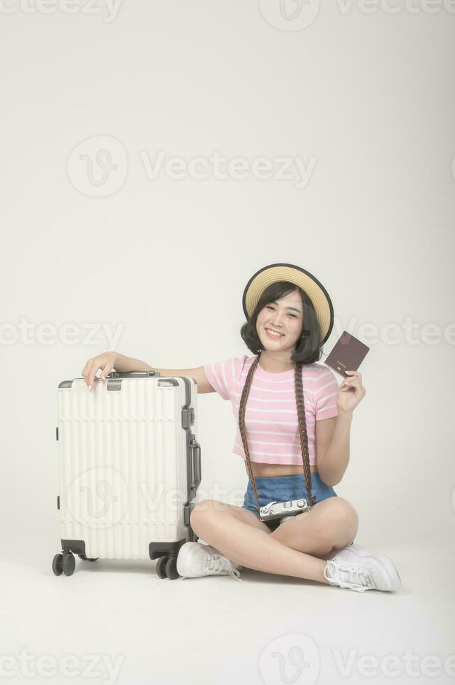 Young happy asian tourist woman over white background studio, travel and holidays concept. photo