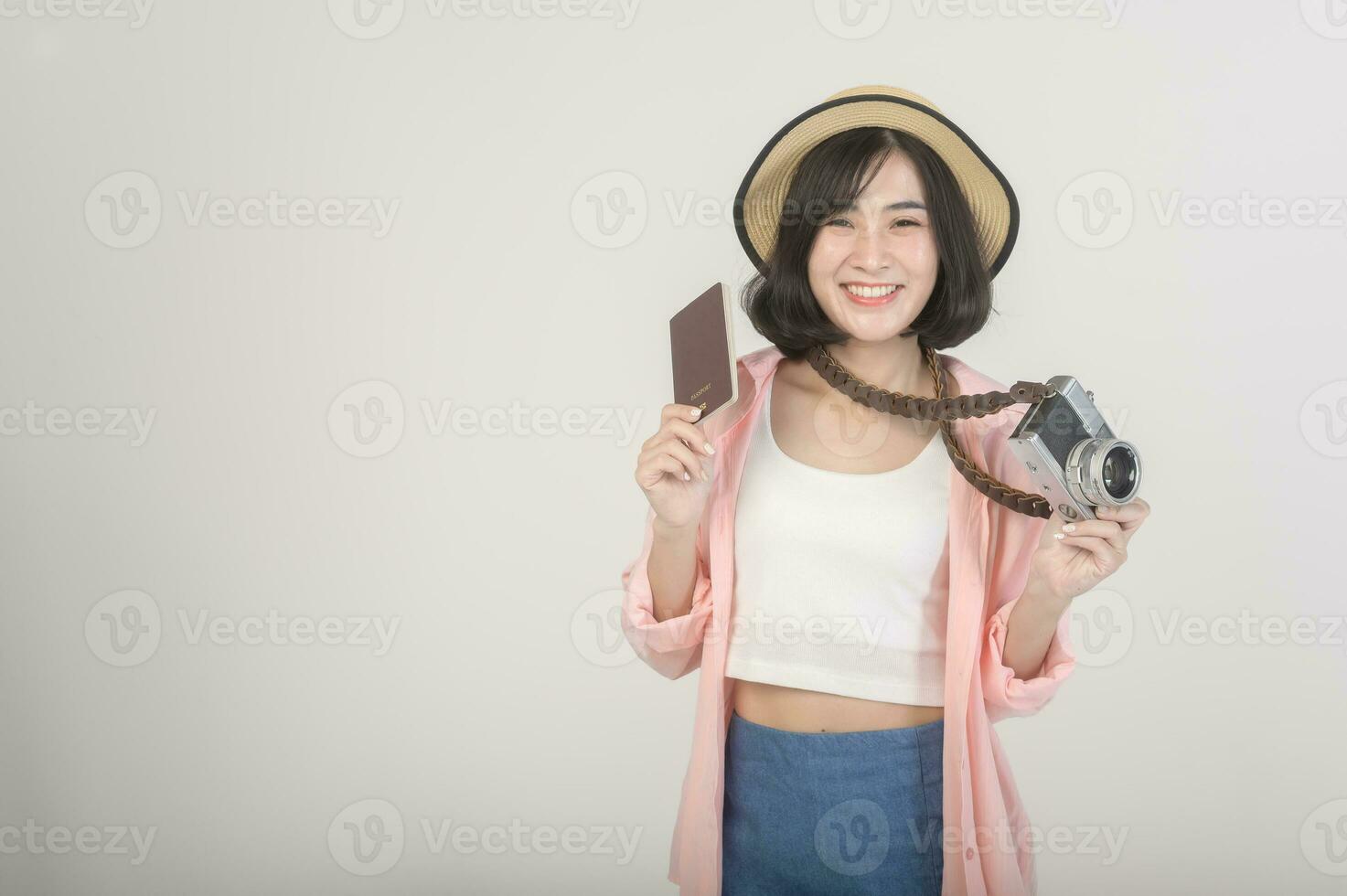 Young happy asian tourist woman over white background studio, travel and holidays concept. photo