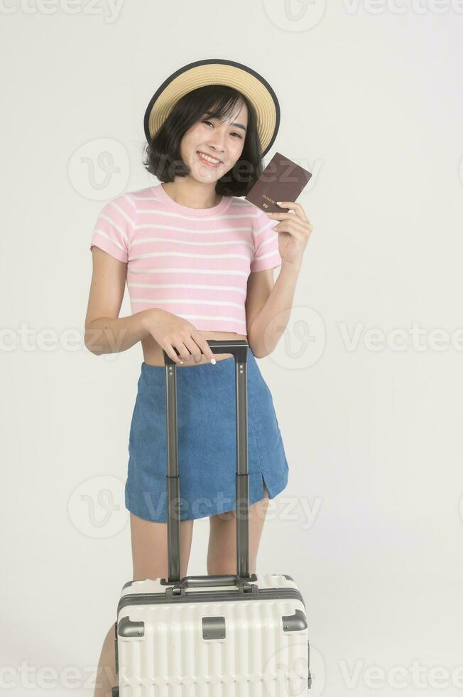 Young happy asian tourist woman over white background studio, travel and holidays concept. photo