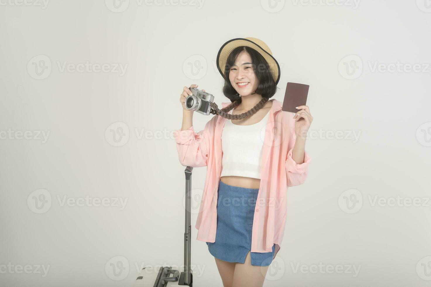 Young happy asian tourist woman over white background studio, travel and holidays concept. photo