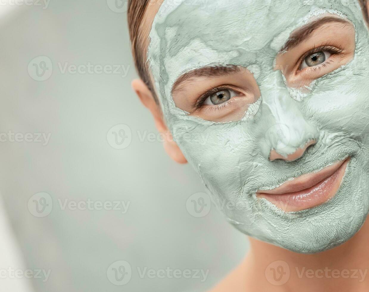 Beautiful girl doing facial mask photo