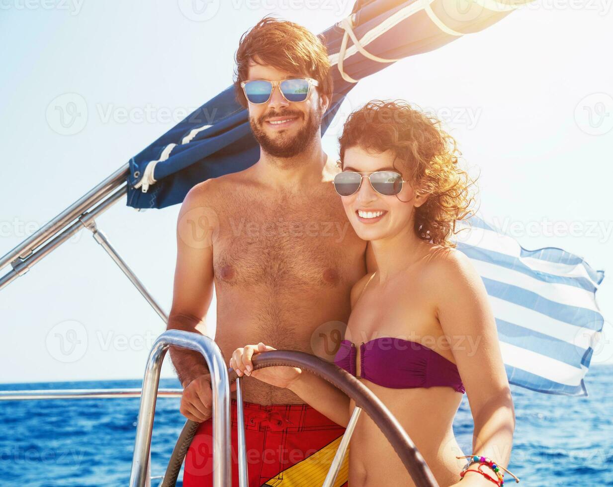 Joyful couple driving sailboat photo