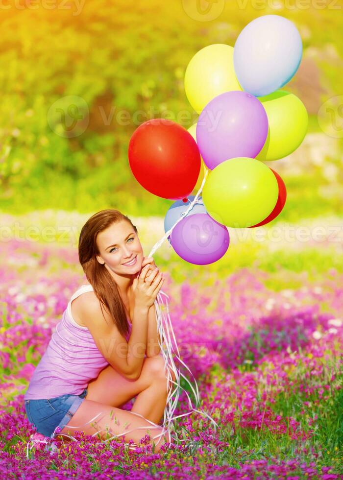 Pretty girl holding colorful balloons photo