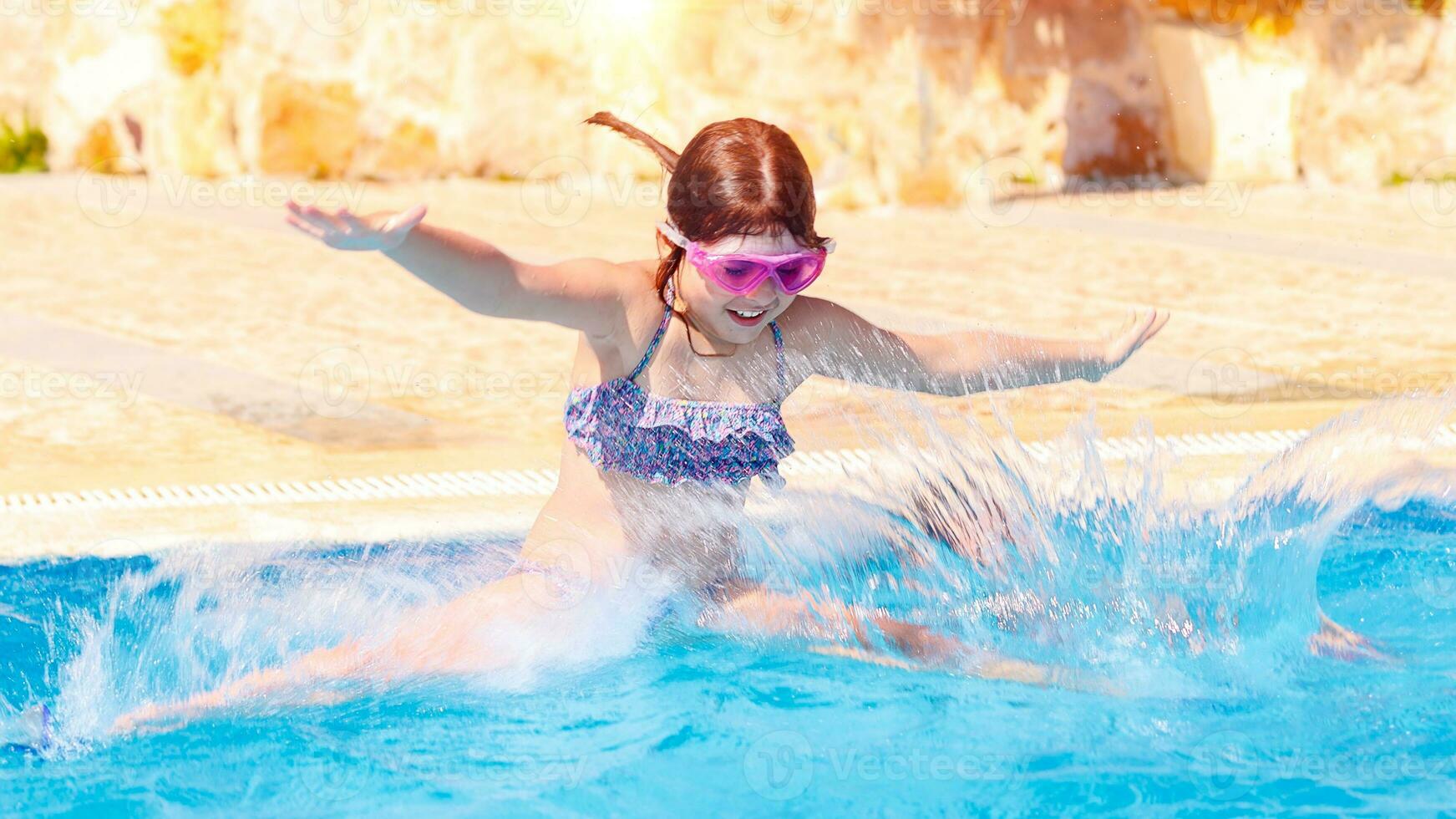 Happy little girl jumping to the pool photo