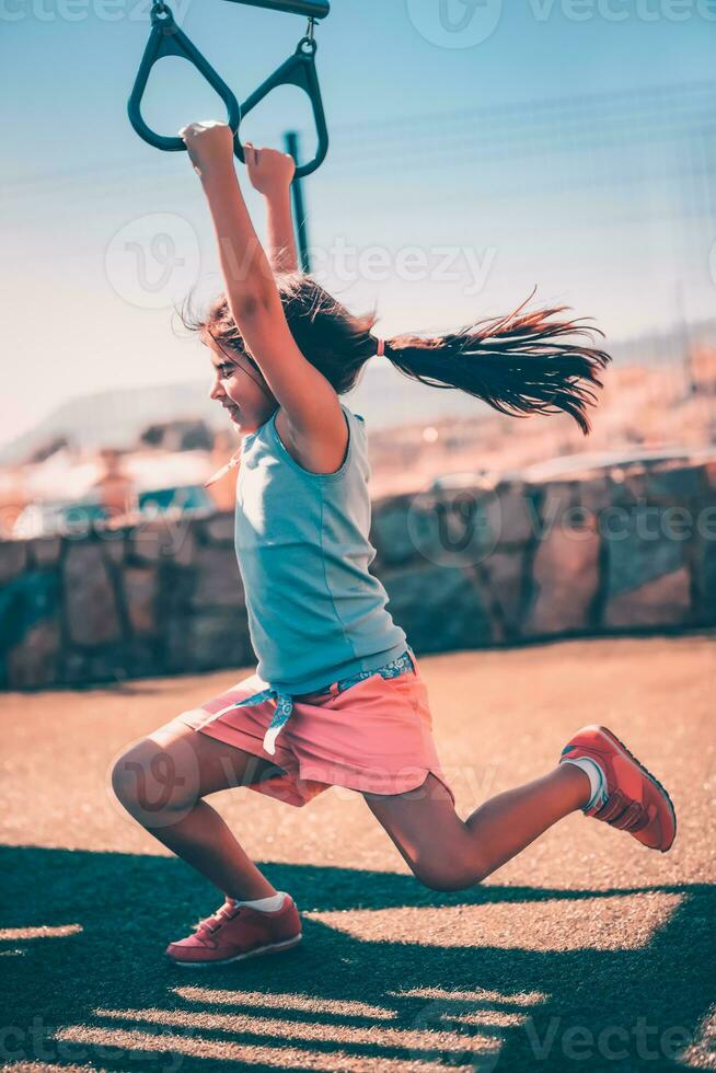 pequeño niña haciendo Deportes en un simulador foto