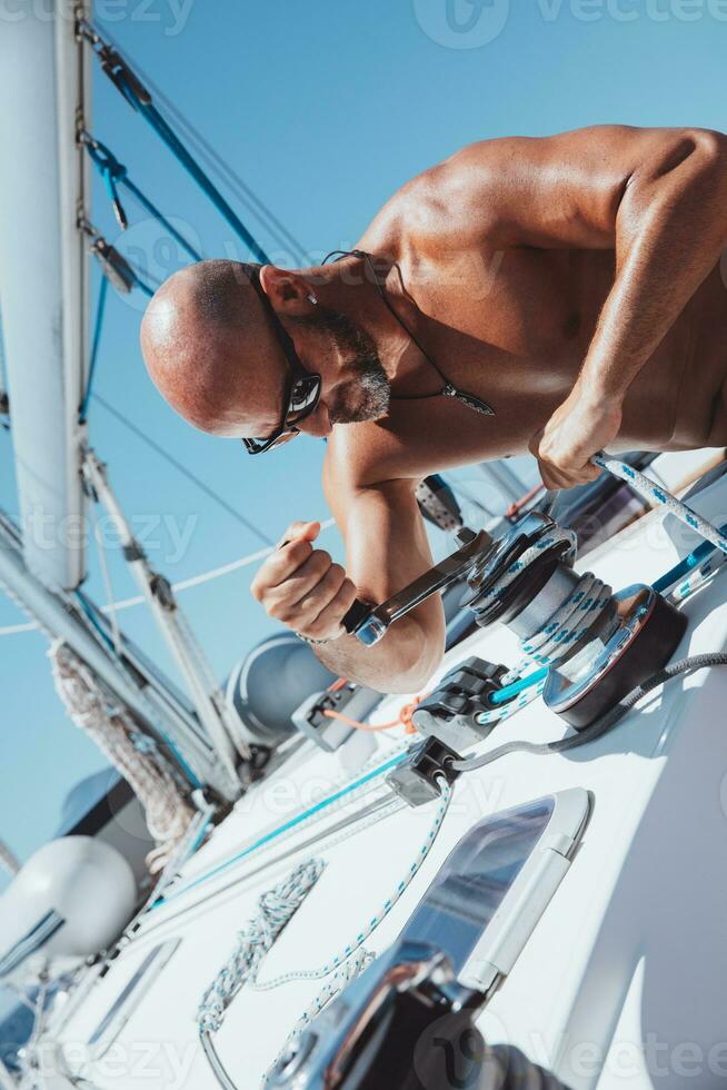 Handsome man sailor working on sailboat photo