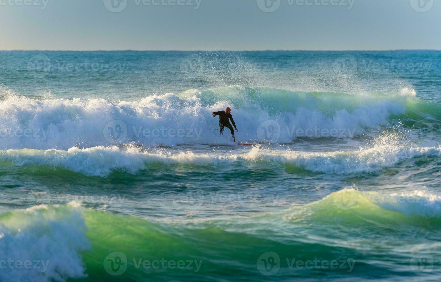 Surfer Riding big glassy waves photo