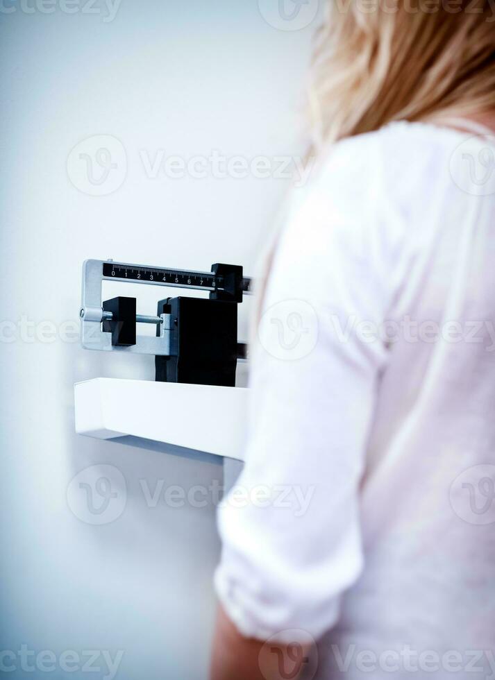 Woman in the clinic checking her weight photo