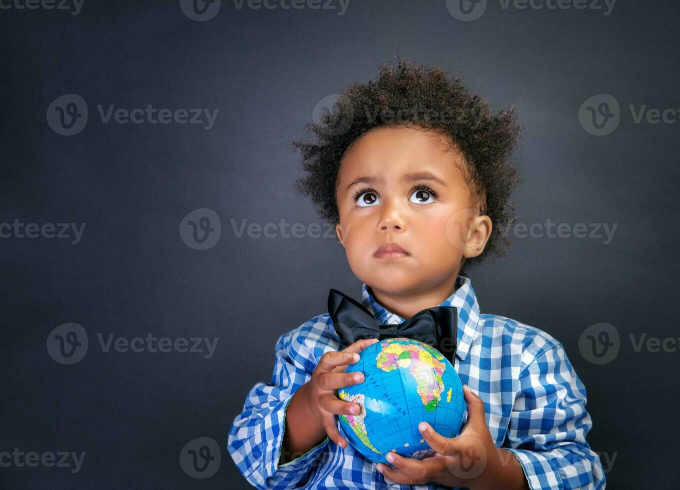 Little schoolboy with globe in hands photo