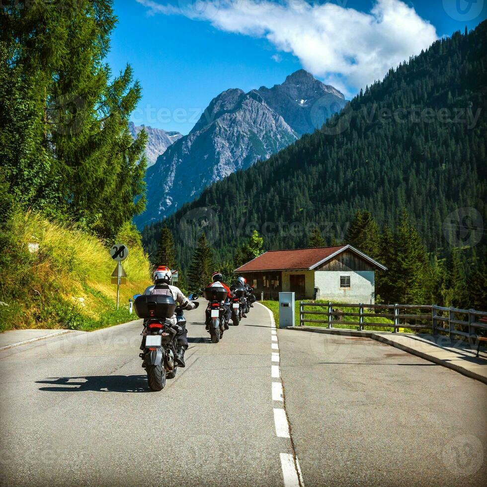 Group of bikers on the road in Alps photo