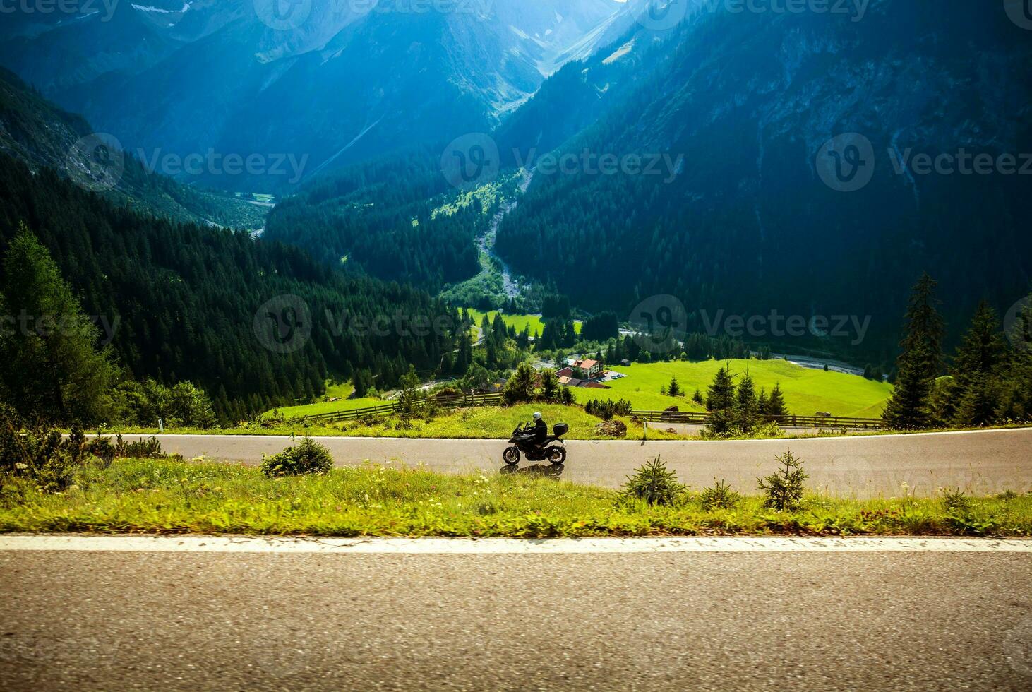Motorcyclist on mountainous highway photo