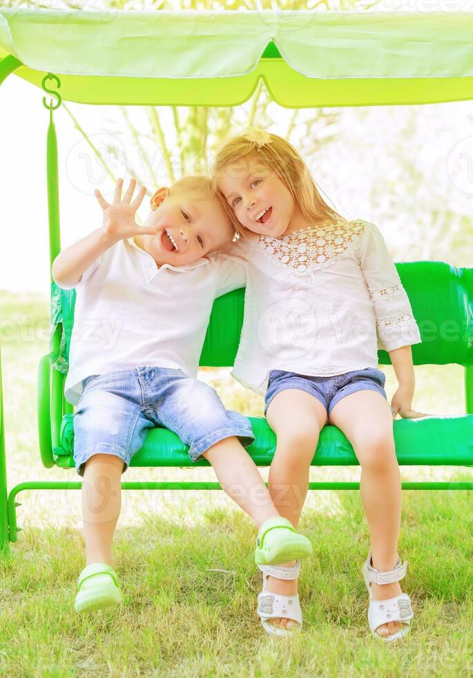 Brother and sister on the swing photo