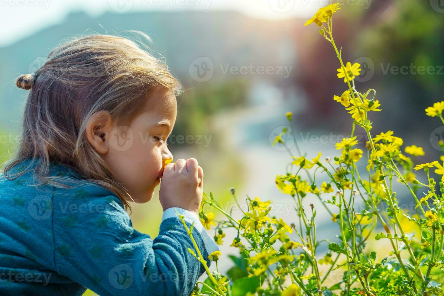 pequeño chico disfrutando flores aroma foto