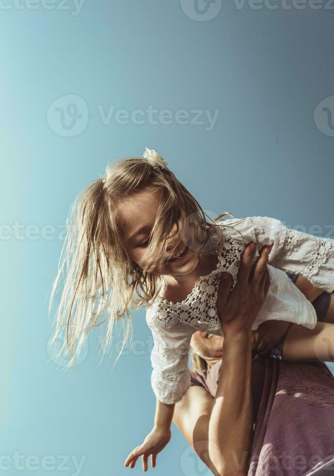 Happy mother and daughter playing outdoors photo