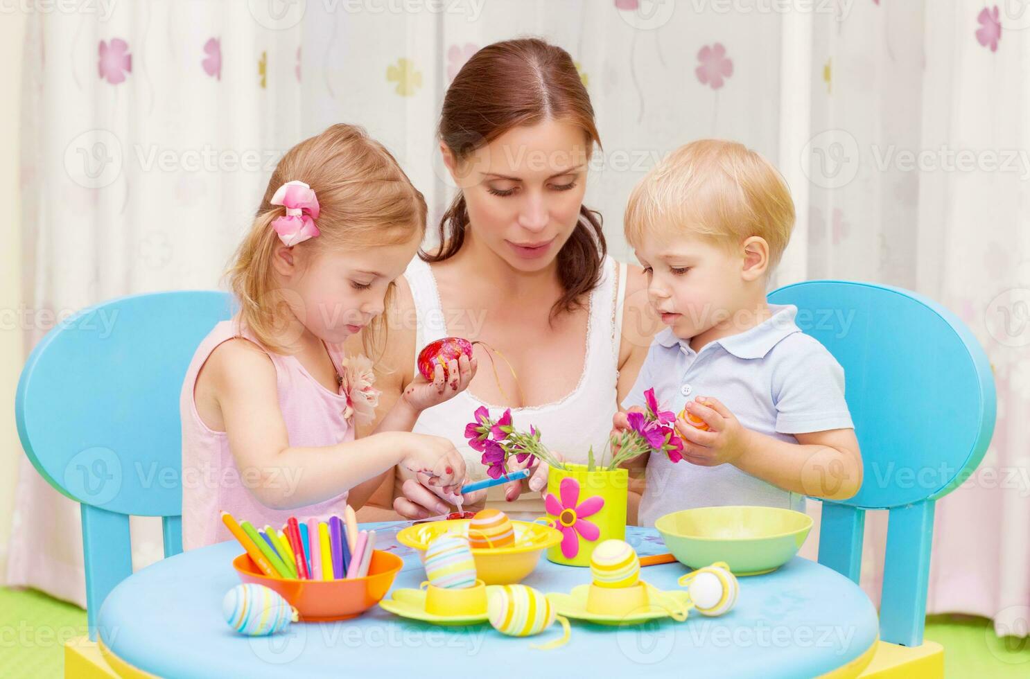 Mother with kids paint Easter eggs photo
