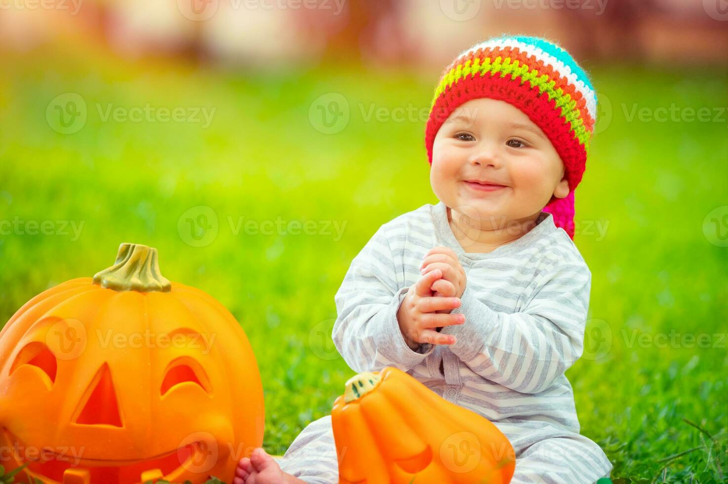 Cute baby playing with pumpkins photo