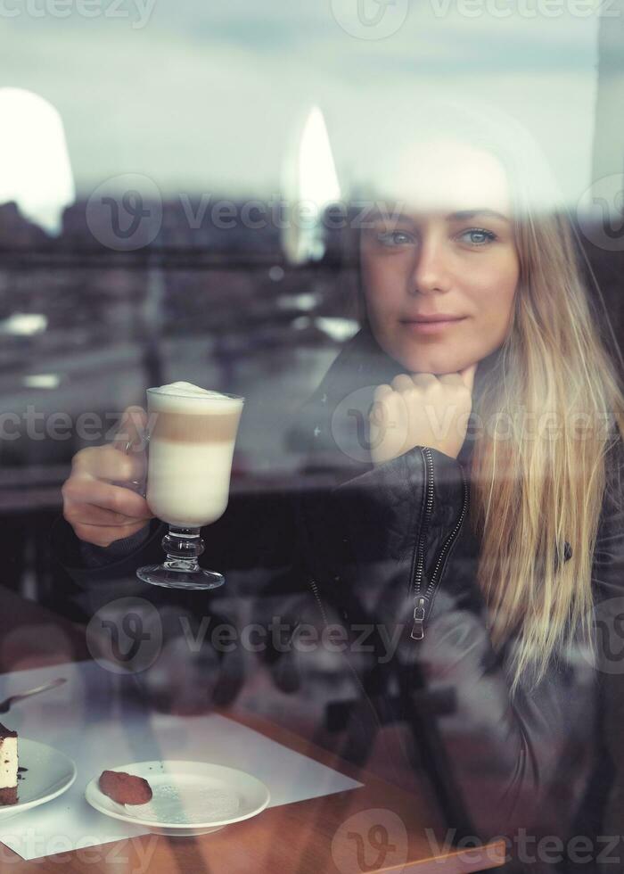 Dreamy girl with latte in cafe photo