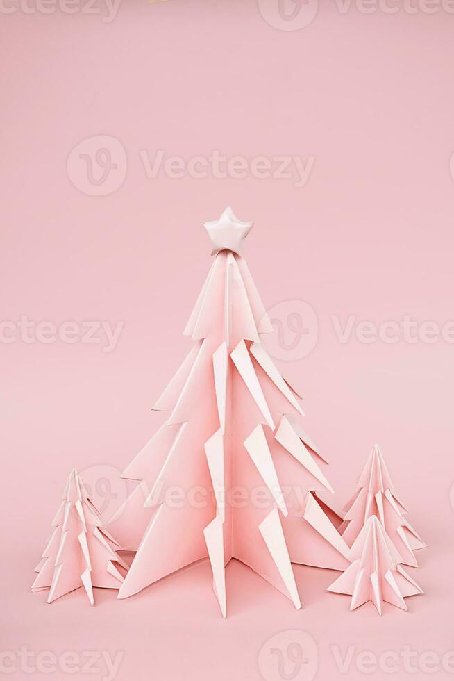 Pink origami Christmas trees. Monochrome winter holidays background. photo