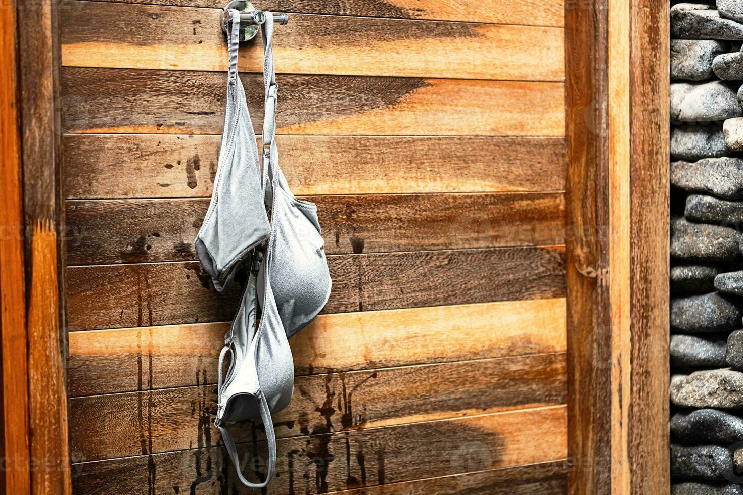 Wet swimsuit hanging on hook after swimming. photo