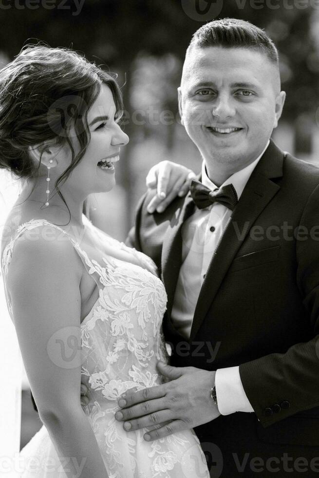 the groom in a brown suit and the bride in a white dress photo