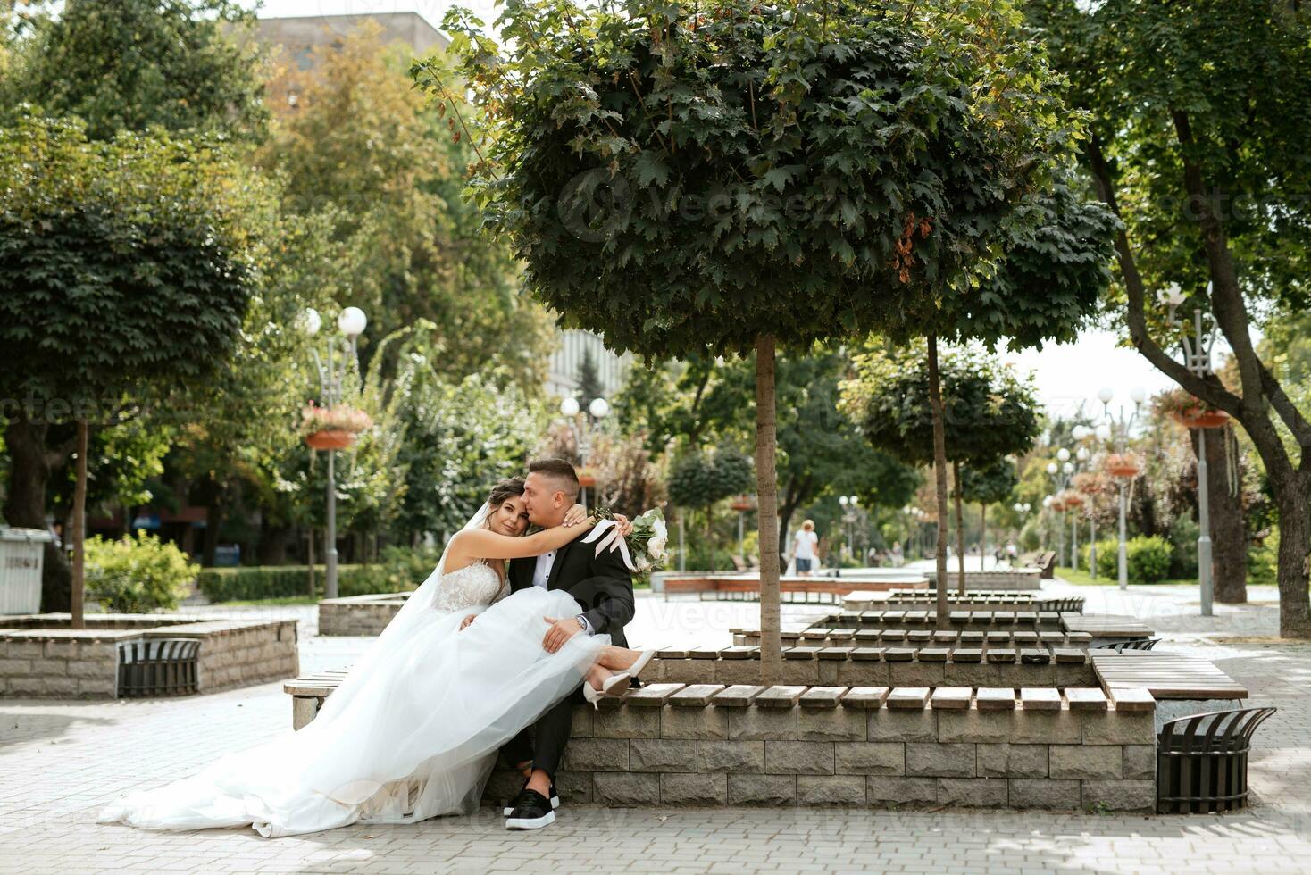 el novio con traje marrón y la novia con vestido blanco foto