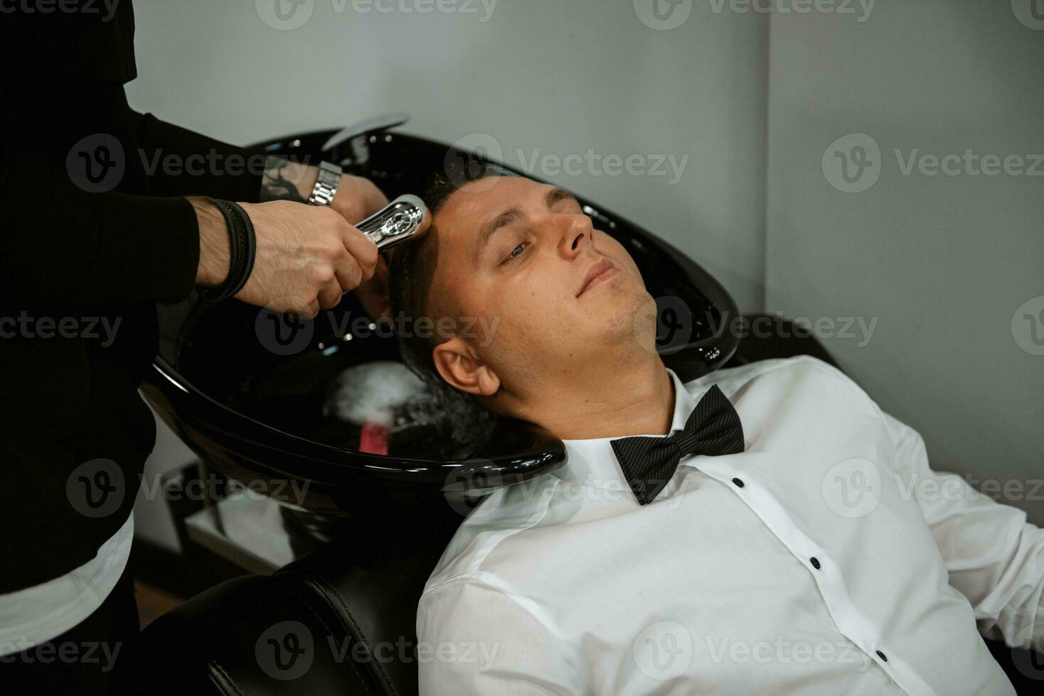 bearded man cutting his beard in the barbershop photo