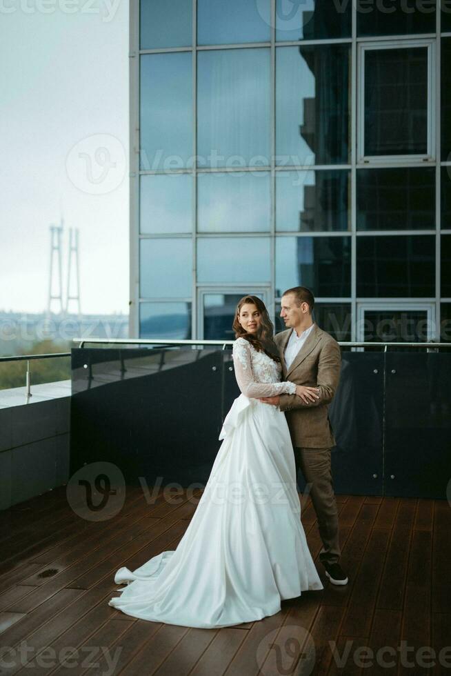 novia y novio primero reunión en el techo de rascacielos foto