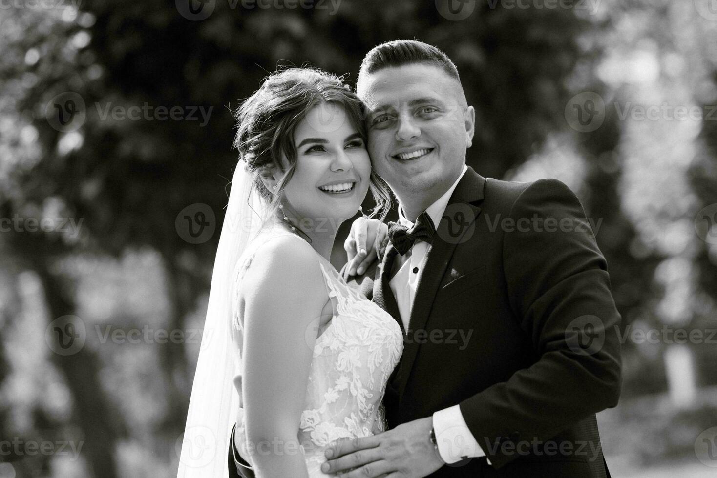 the groom in a brown suit and the bride in a white dress photo