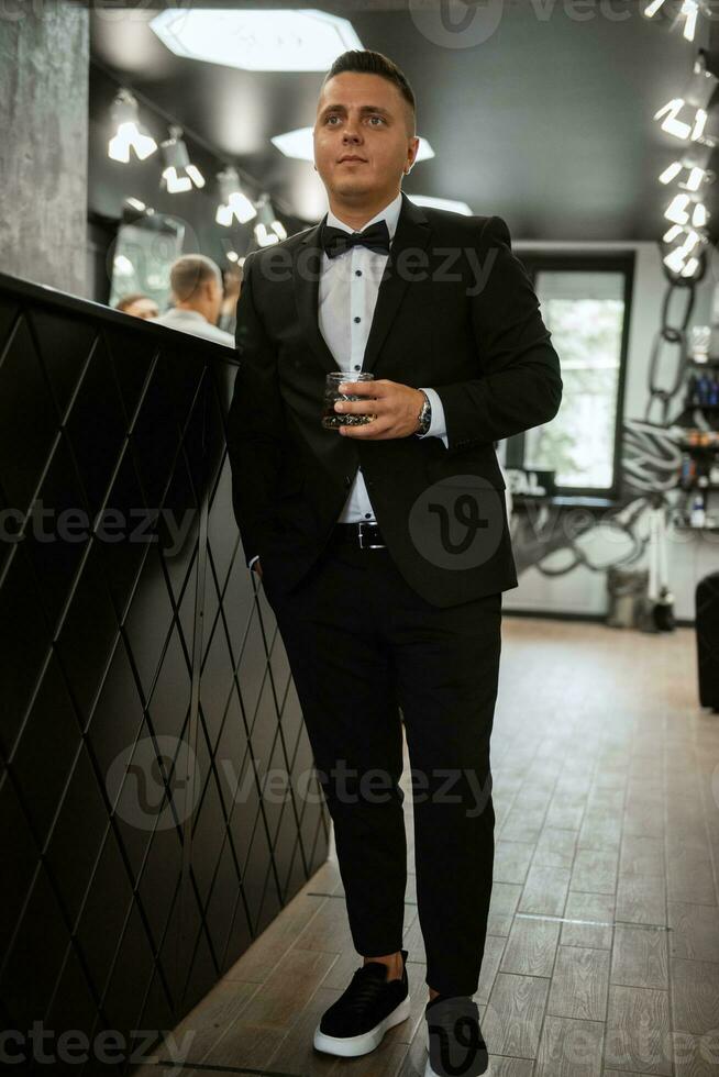 hombre barbudo cortándose la barba en la barbería foto