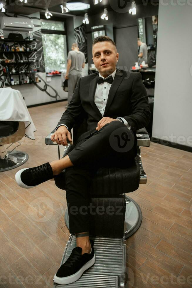 hombre barbudo cortándose la barba en la barbería foto