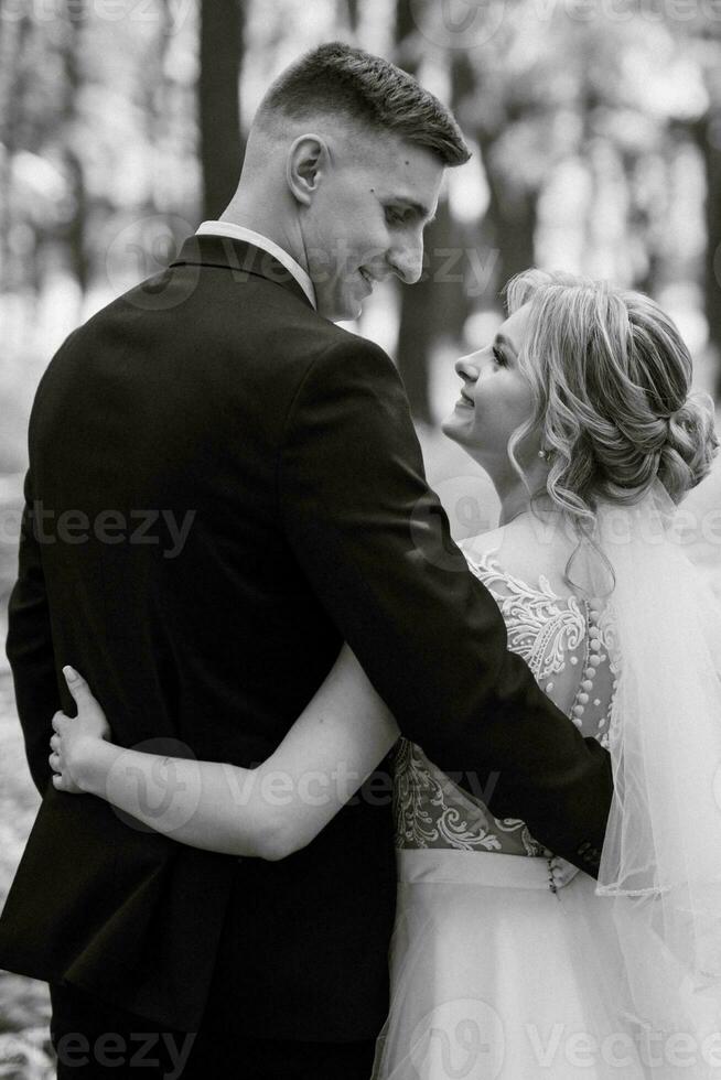 the groom and the bride are walking in the forest photo