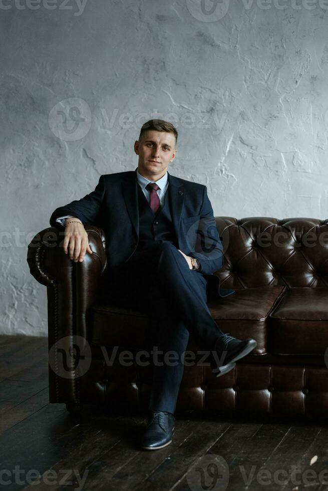 portrait of a cheerful groom in a blue suit photo