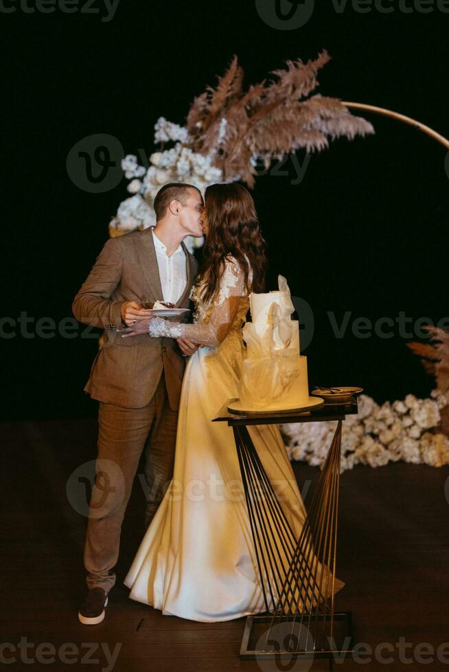 newlyweds happily cut and taste the wedding cake photo