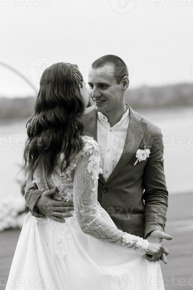 the first wedding dance of the bride and groom on the pier near the river photo